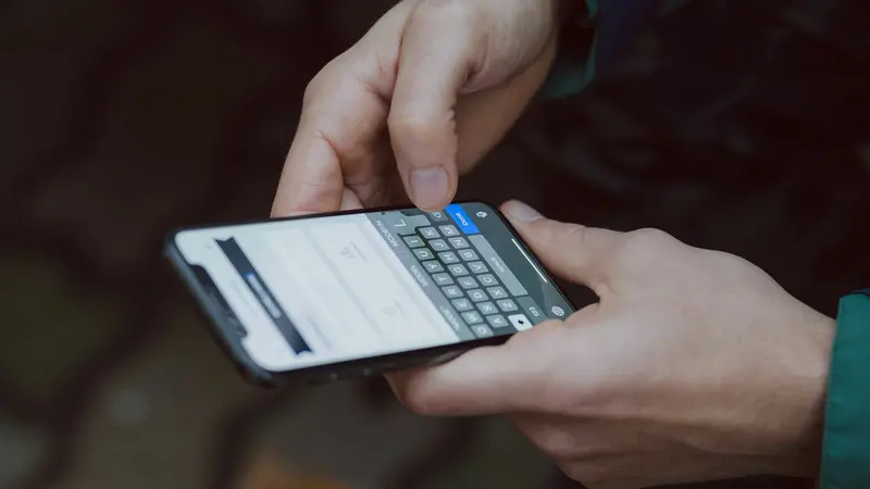 Close de mãos digitando uma mensagem em um smartphone